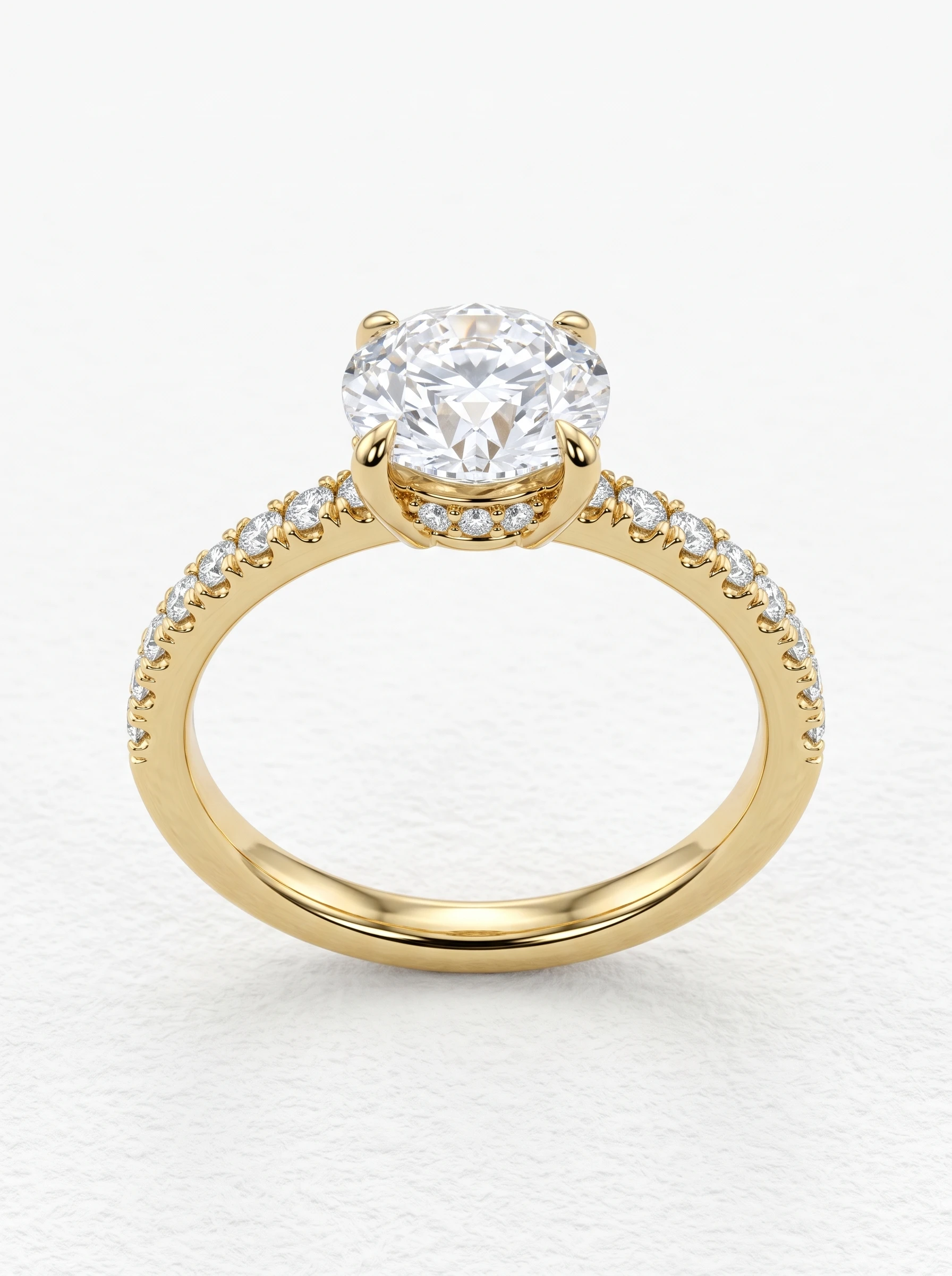 Round hidden halo pave engagement ring in yellow gold standing upright, four claw prongs and pavé shoulders