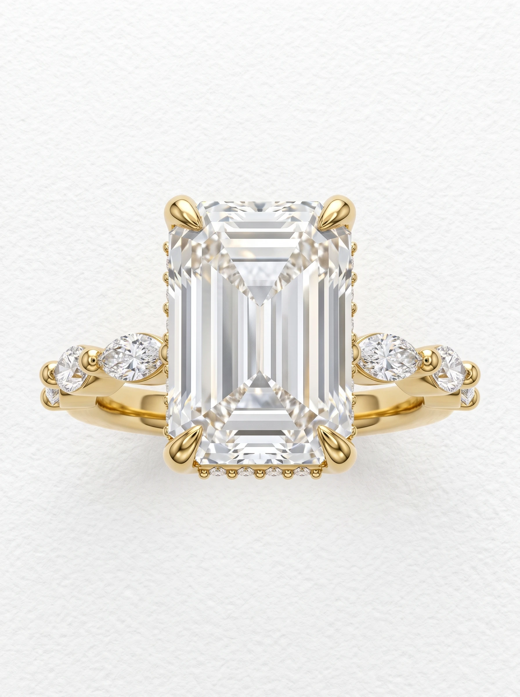 Emerald cut hidden halo engagement ring in yellow gold, front view with claw prongs and marquise diamond shoulders