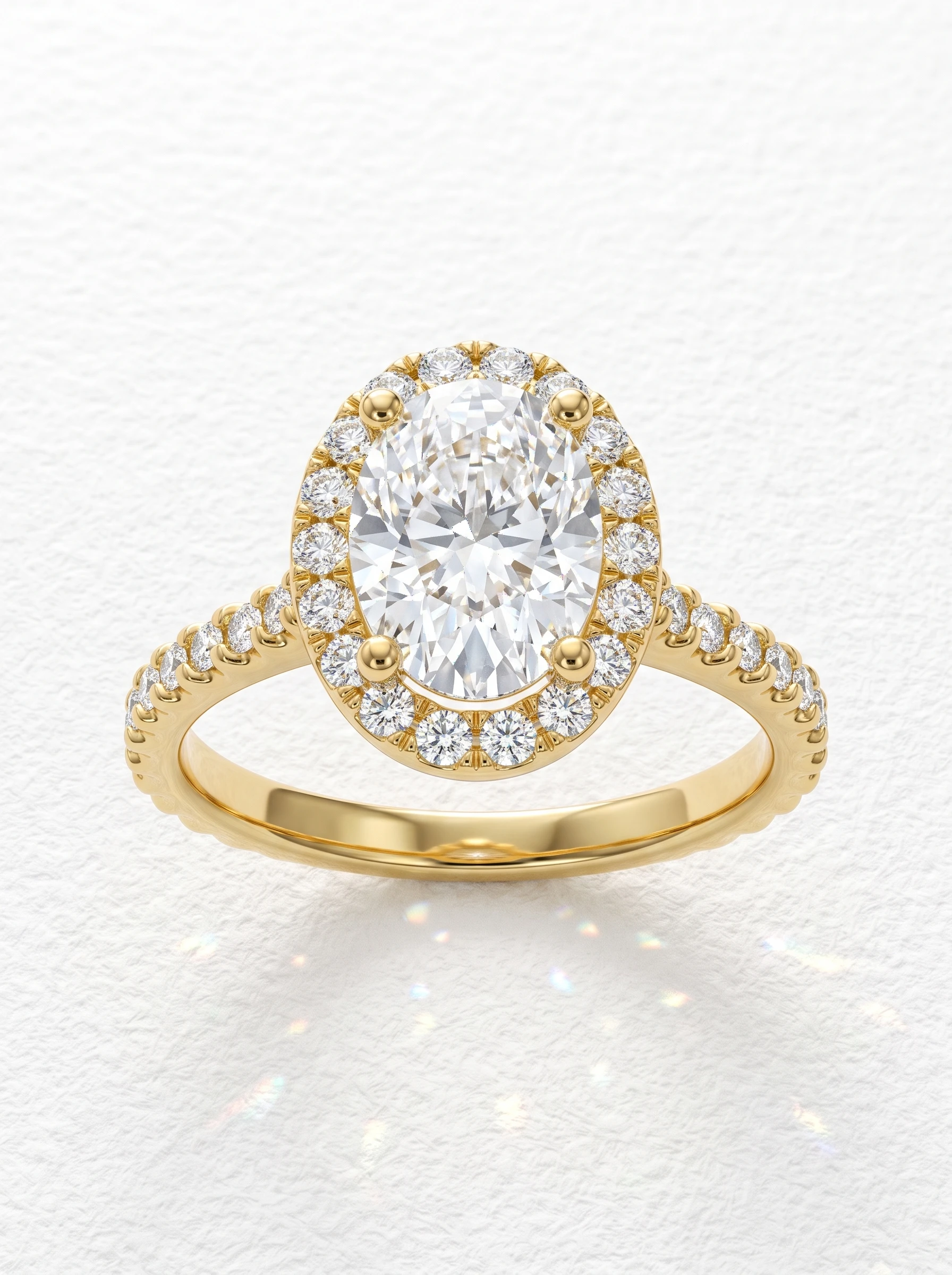 Oval halo pave engagement ring in yellow gold, oval center stone with round halo and pave shank