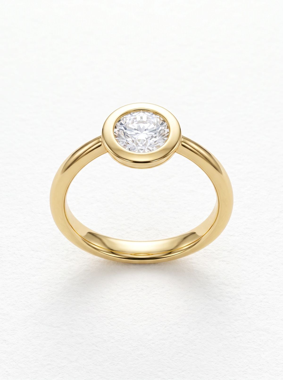 Bague de fiançailles ronde serti clos en or jaune posée droite, rebord poli et anneau arrondi