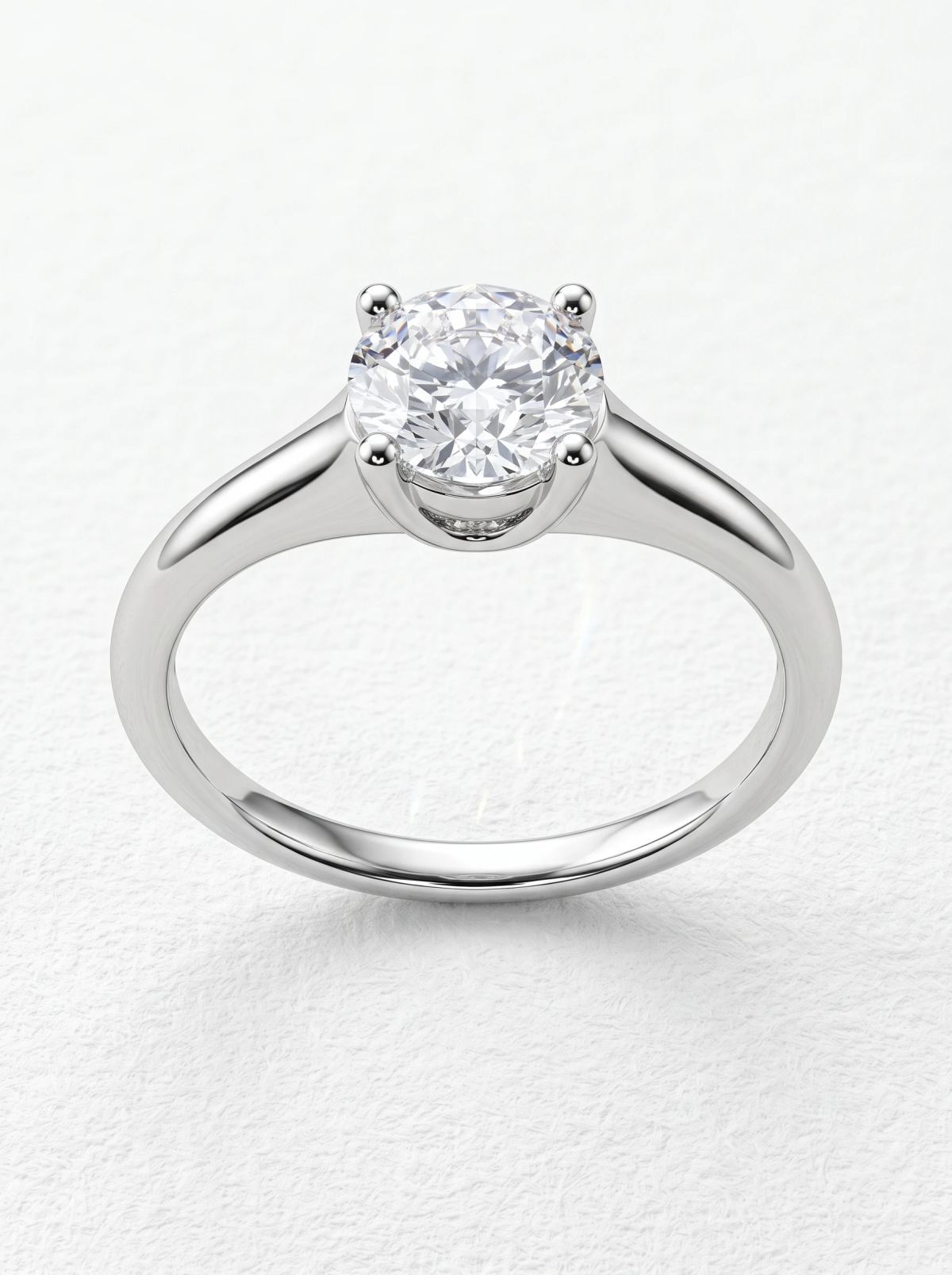 Bague de fiançailles solitaire taille ronde en or blanc vue de face, quatre griffes arrondies et épaules effilées