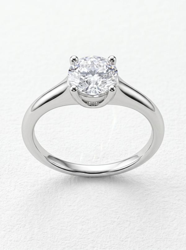 Bague de fiançailles solitaire taille ronde en or blanc vue de face, quatre griffes arrondies et épaules effilées