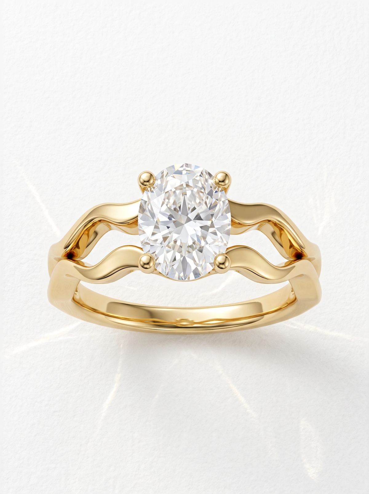 Vue de face d'une bague ovale à quatre griffes en or jaune sur anneau divisé ondulé ajouré