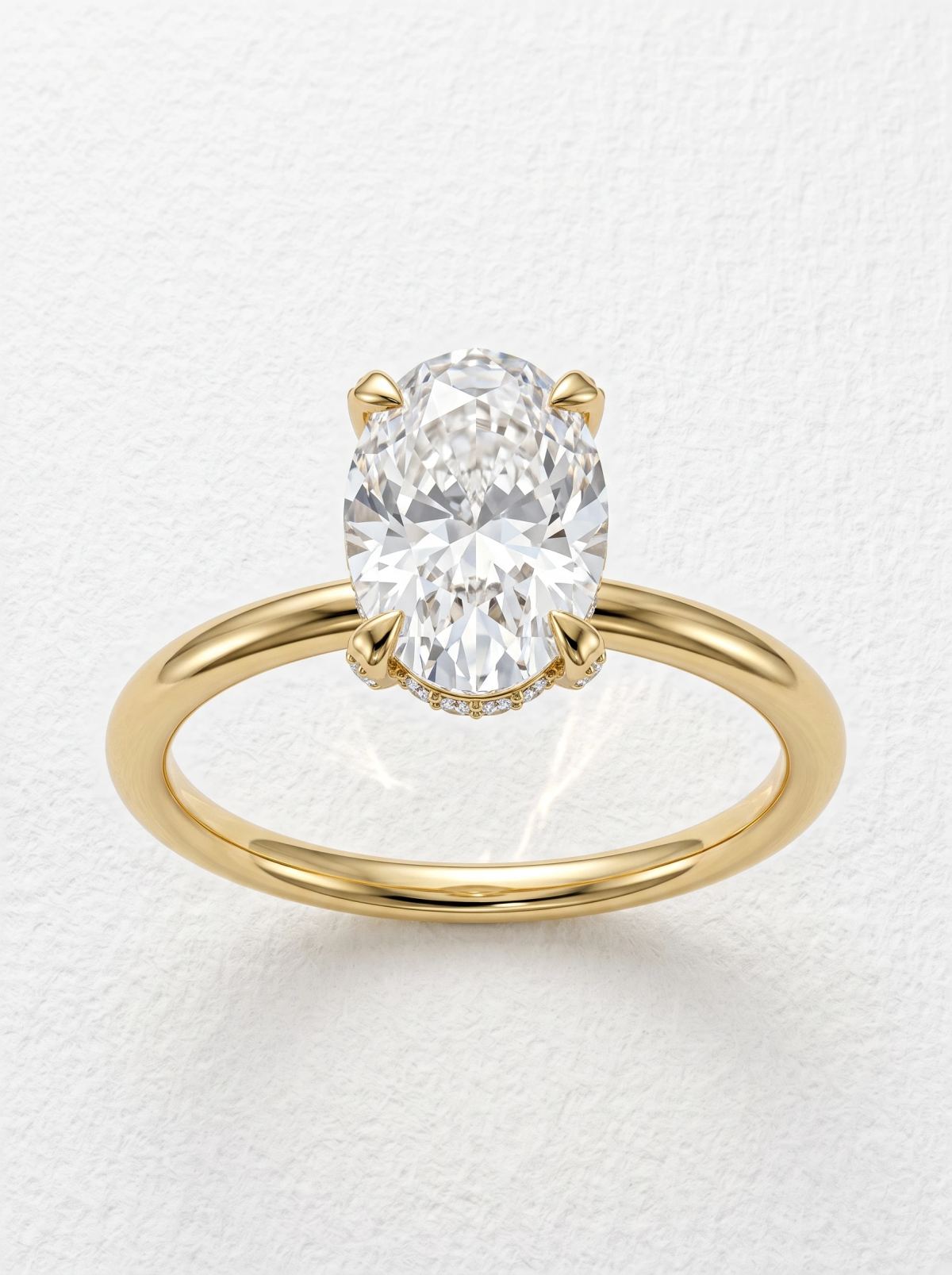 Bague de fiançailles ovale halo caché pavé en or jaune, vue de face de l'ovale tenu par quatre griffes
