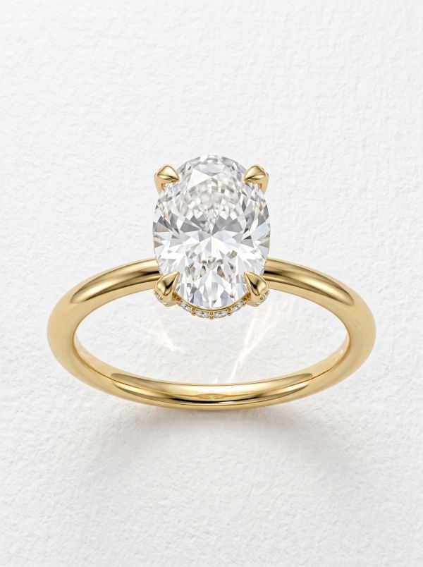 Bague de fiançailles ovale halo caché pavé en or jaune, vue de face de l'ovale tenu par quatre griffes