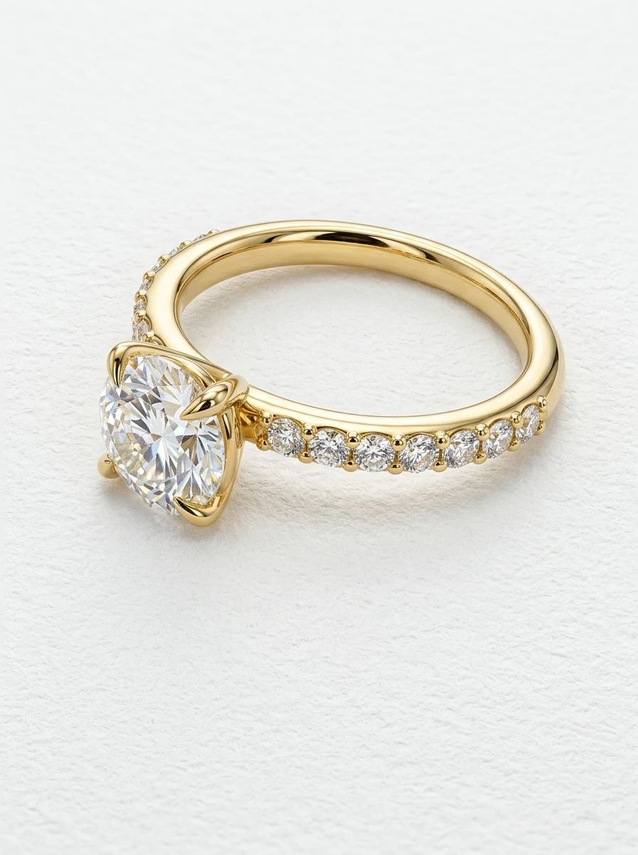 Bague de fiançailles diamant rond en or jaune couchée sur le côté, anneau pavé et corps de bague poli