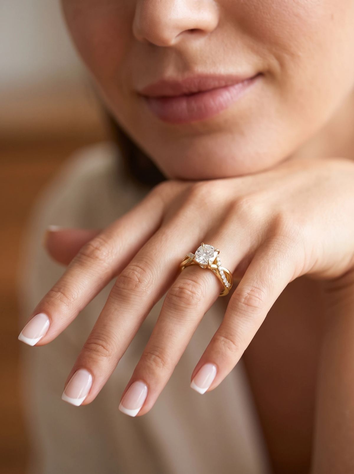 Bague de fiançailles coussin torsadée en or jaune portée sur une main posée sous le menton