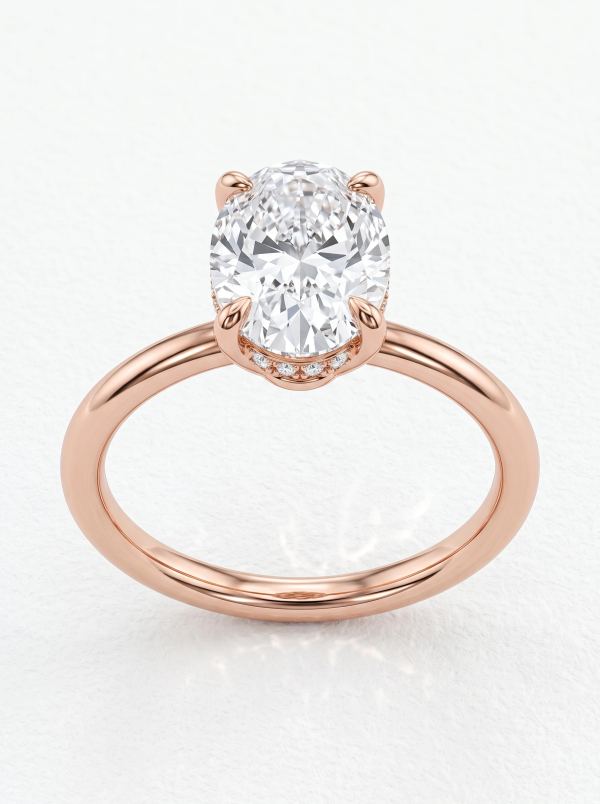 Bague de fiançailles solitaire ovale halo caché en or rose vue de face, quatre griffes et anneau fin