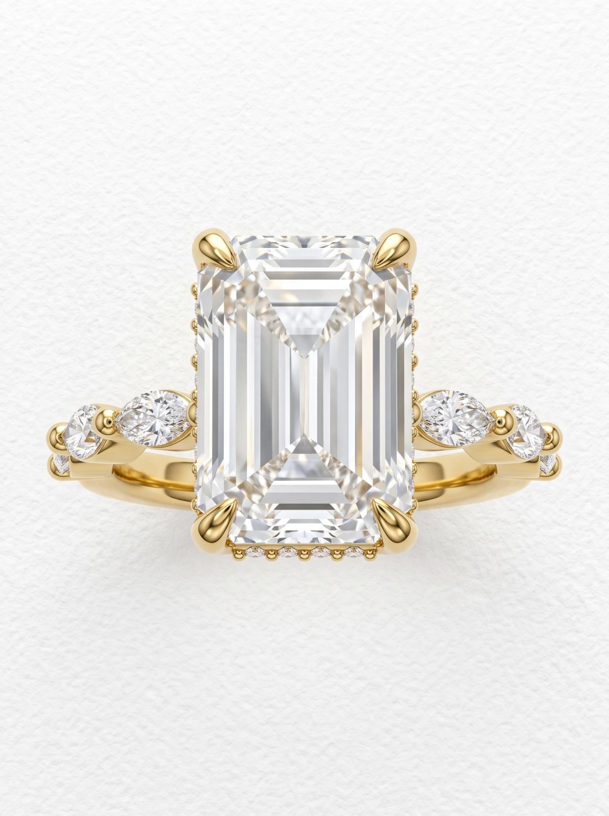 Bague de fiançailles taille émeraude halo caché en or jaune, vue de face, griffes et épaules serties de marquises