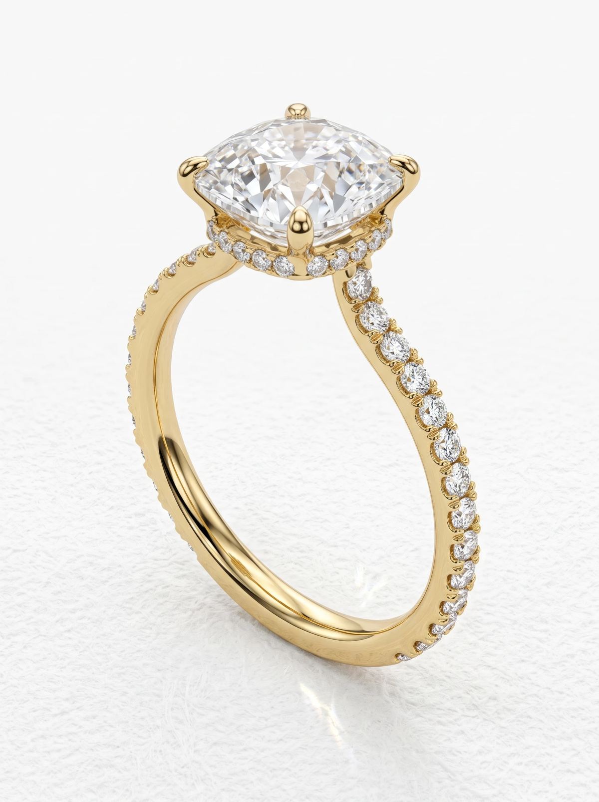 Bague coussin en or jaune, vue de trois quarts montrant le halo caché sous la pierre centrale