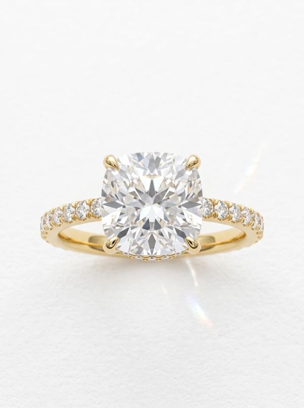 Bague de fiançailles coussin halo caché pavé en or jaune, posée droite sur l'anneau