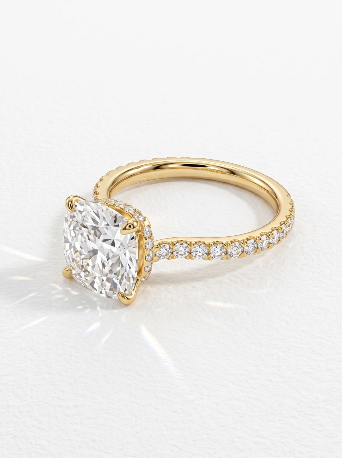 Profil d'une bague en or jaune avec halo caché et diamants pavés sur l'anneau