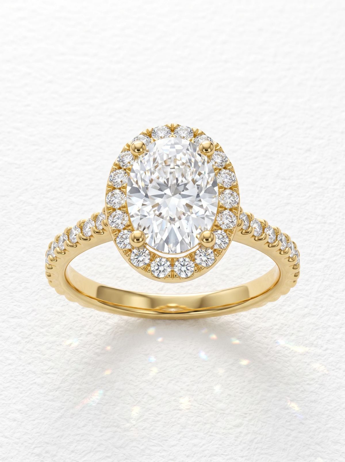 Bague de fiançailles ovale halo pavé en or jaune, pierre centrale ovale entourée d'un halo pavé