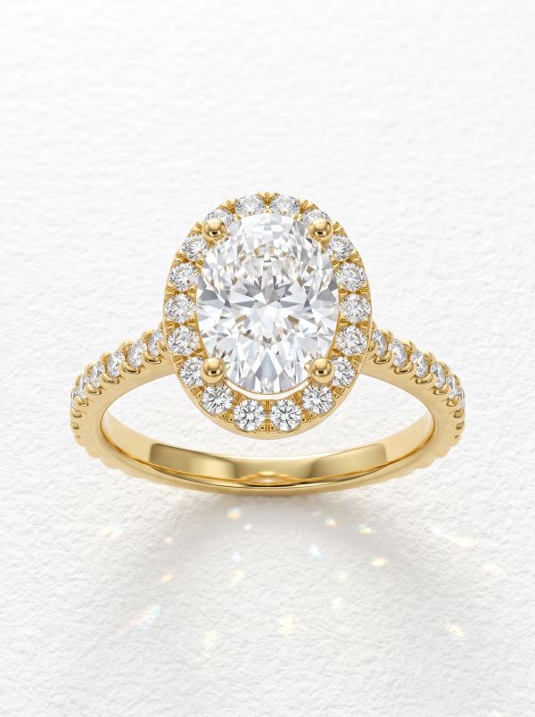 Bague de fiançailles ovale halo pavé en or jaune, pierre centrale ovale entourée d'un halo pavé