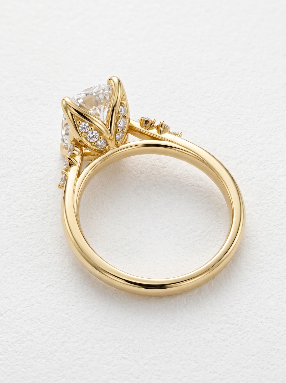 Vue arrière d'une bague de fiançailles en or jaune couchée, panier en pétales de tulipe serti de diamants