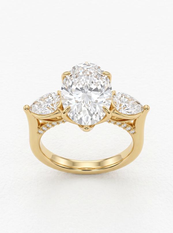 Bague de fiançailles trilogie ovale et poires en or jaune, vue de face avec six griffes et pont pavé