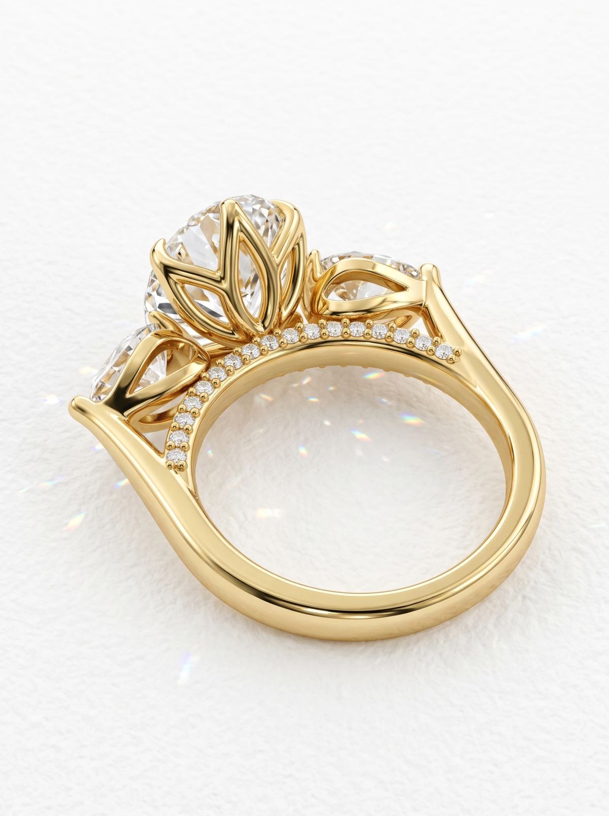 Vue arrière d'une bague trilogie ovale en or jaune montrant la galerie en pétales de lotus