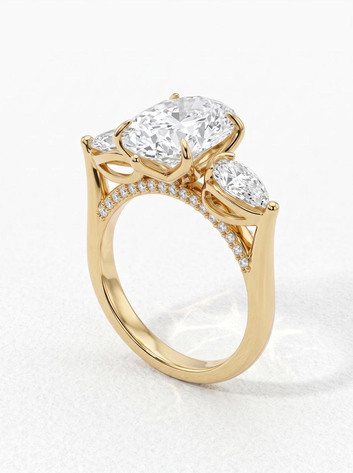 Bague trilogie ovale en or jaune posée de biais, pont pavé incurvé le long de la galerie