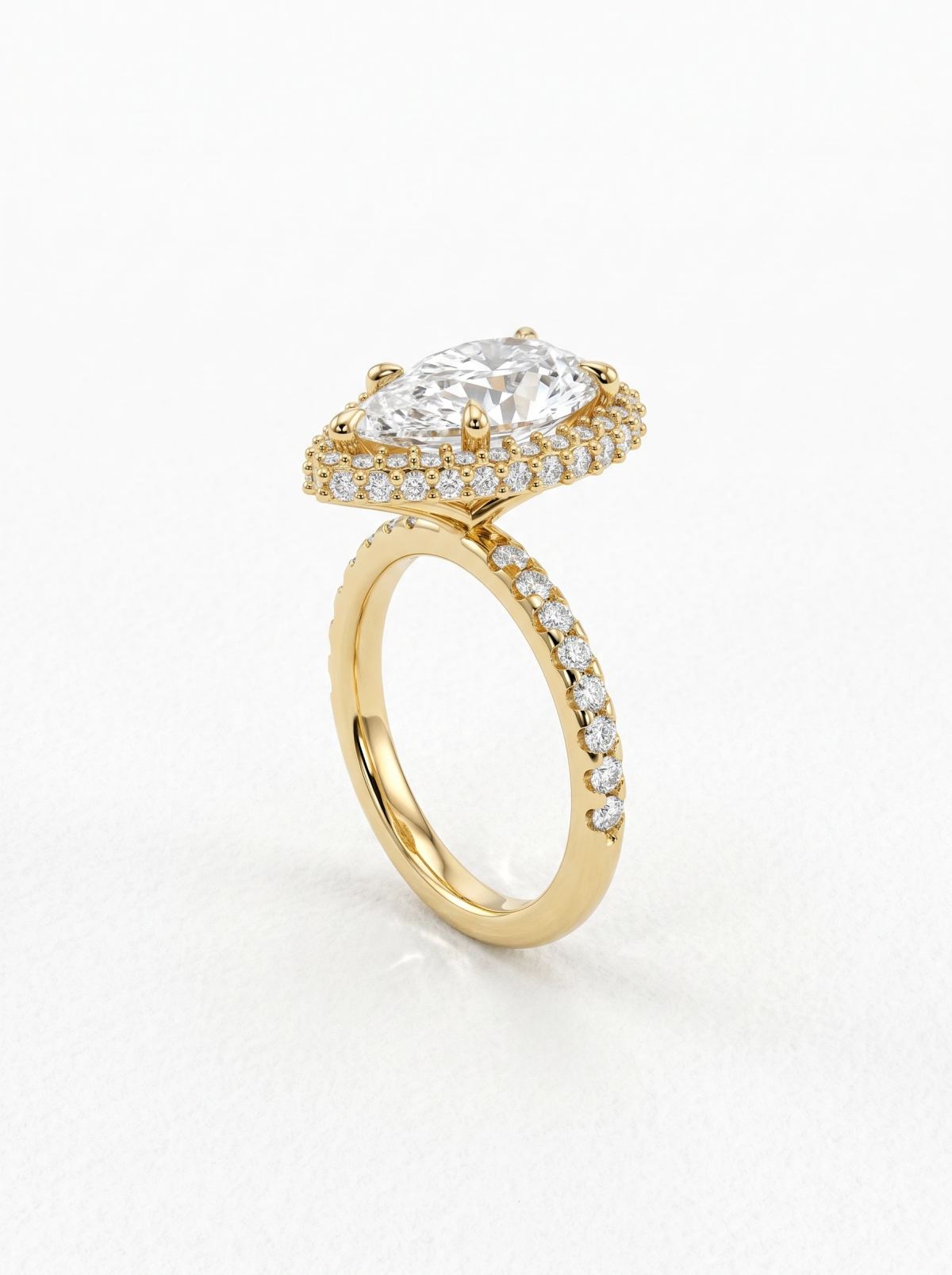 Bague poire à halo en or jaune posée droite de profil, galerie en V et deux rangées de diamants superposées